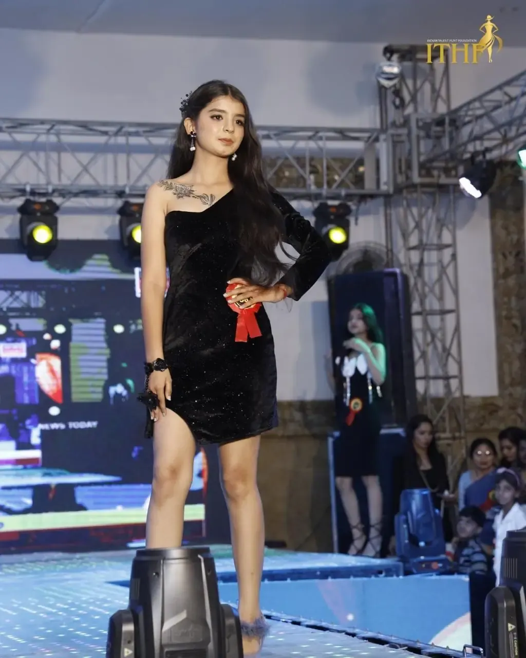 A contestant in a black dress on the ramp during a modelling round